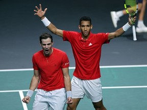 Montreal's Félix Auger-Aliassime, right, and Vasek Pospisil celebrate after winning the men's double semifinal tennis match of the Davis Cup tournament between Italy and Canada at the Martin Carpena sports hall in Malaga, Spain, on Saturday, Nov. 26, 2022.