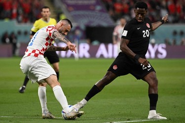 Croatia's midfielder #11 Marcelo Brozovic and Canada's forward #20 Jonathan David fight for the ball during the Qatar 2022 World Cup Group F football match between Croatia and Canada at the Khalifa International Stadium in Doha on Nov. 27, 2022.