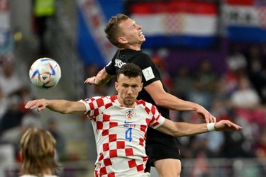 Croatia's midfielder #04 Ivan Perisic and Canada's defender #02 Alistair Johnston jump for a header during the Qatar 2022 World Cup Group F football match between Croatia and Canada at the Khalifa International Stadium in Doha on Nov. 27, 2022.