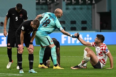 Canada's goalkeeper #18 Milan Borjan helps a Croatian player stand up after being defeated by Croatia 4-1 in the Qatar 2022 World Cup Group F football match between Croatia and Canada at the Khalifa International Stadium in Doha on Nov. 27, 2022.