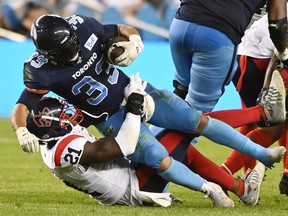 Toronto Argonauts running-back Andrew Harris is tackled by Montreal Alouettes linebacker Chris Ackie in Toronto on June 16, 2022.