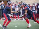 Montreal Alouettes quarterback Trevor Harris hands off to tailback William Stanback during first half against the Toronto Argonauts in Montreal on Oct. 22, 2022.