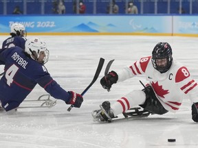 Tyler McGregor, right, of Canada and Brody Roybal of the United States battle for the puck during their para ice hockey finals match at the 2022 Winter Paralympics, Sunday, March 13, 2022, in Beijing. Women's team stars Marie-Philip Poulin and Sarah Nurse, Indigenous trailblazer Brigette Lacquette and men's para hockey captain McGregor are among the Canadian hockey stars teaming with Tim Hortons on a new hockey diversity and inclusion campaign.