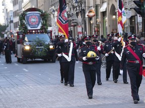 The procession arrives at the church for funeral services for fireman Pierre Lacroix in Montreal, Friday, Oct. 29, 2021. A coroner's inquest is underway into the drowning death of Montreal firefighter Pierre Lacroix, who perished during a rescue mission in the St. Lawrence River.