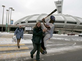 Karina Dedelis carries an autographed cut-out of Vladimir Guerrero while her mother totes other Expos souvenir bags, on Dec. 3, 2004.