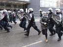 Riot police charge during an anti-police brutality demonstration in Montreal on March 15, 2013. The city of Montreal will pay more than $3 million to hundreds of protesters whose rights were violated by police.