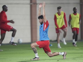 Canada midfielder Jonathan Osorio stretches during practice at the World Cup in Doha, Qatar, on Sunday, Nov. 20, 2022.