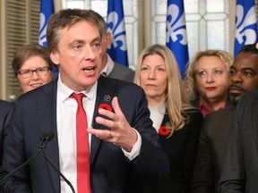 Quebec Liberal interim Leader Marc Tanguay speaks during a news conference at the Legislature in Quebec City on Nov. 10, 2022, with members of his caucus including Frantz Benjamin, far right.