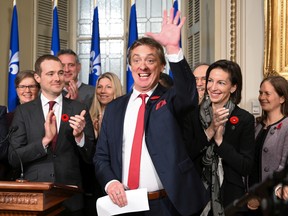 Interim Quebec Liberal Party leader Marc Tanguay waves to Liberal workers while applauded by the party's caucus and president Rafael Primeau-Ferraro, left, at a news conference at the legislature in Quebec City, Thursday, Nov. 10, 2022. Tanguay was chosen by the Liberals to replace Dominique Anglade, who resigned this week.