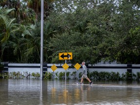 A man wallks through a flooded street following the passage of Hurricane Nicole in Vero Beach, Florida on Thursday, Nov. 10, 2022.