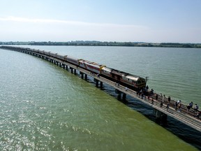 Tourists enjoy the view as a train stops at the middle of Pasak Jolasid Dam in Lopburi province, Thailand, Nov. 6, 2022.