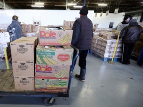 Volunteers sort pallets of food at Moisson Montreal in 2019. "I have recently spoken to several people who have always made a habit of supporting local food banks year-round, but especially during the holiday season. They have admitted to not being able to give as generously as they usually would," Fariha Naqvi-Mohamed writes.