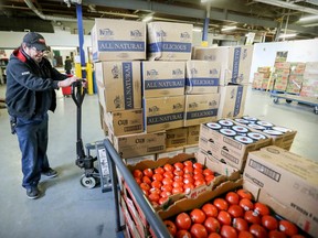 Volunteer Ernest Adams uses a hand truck to move pallets of food at Moisson Montreal food bank on Jan. 7, 2019.