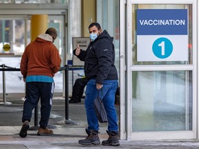 A man gives a thumbs-up as he enters a COVID-19 vaccination clinic in the St-Laurent borough of Montreal on in February 2022.