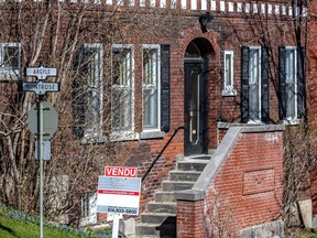 A red brick building has a "sold" sign in its front yard.