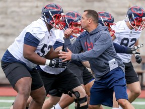 Montreal Alouettes assistant coach André Bolduc takes on offensive-lineman Jarvis Harrison during rookie camp in Montreal on May 15, 2019.
