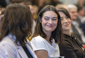 Sophia Roy smiles at her mother, Nathalie Sioris, during Monday’s ceremony at Polytechnique Montréal. At right is Nathalie Provost, a survivor of the 1989 shooting rampage that killed 14 women at the school.