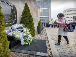 Former Quebec Liberal leader Dominique Anglade brings white roses to the December 6 commemorative plaque during a ceremony at École Polytechnique Dec. 6, 2022, remembering the victims of the massacre in 1989.  Anglade graduated from Polytechnique in 1996.