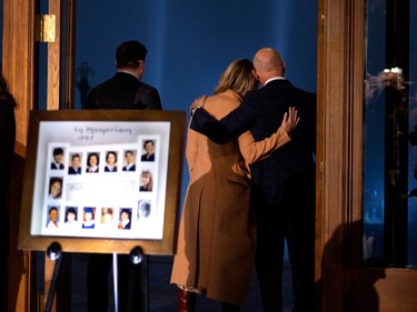 David Lametti, federal minister of justice, takes a moment to view 14 white light beams projected in to the sky after laying a rose next to a photo montage of the victims to mark the anniversary of the massacre at Ecole Polytechnique in Montreal, on Tuesday, Dec. 6, 2022. Of the 14 roses, 10 were laid by politicians.