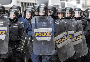 Riot police from Quebec City make a show of force as anti-capitalist demonstrators walk through the streets of Montreal protesting the COP15 conference on Dec. 7, 2022
