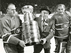 Former Canadiens coach Hector (Toe) Blake, centre, gets a helping hand from Maurice (Rocket) Richard, left, and Jacques Plante carrying the Stanley Cup on the Forum ice, on Dec. 17, 1983.