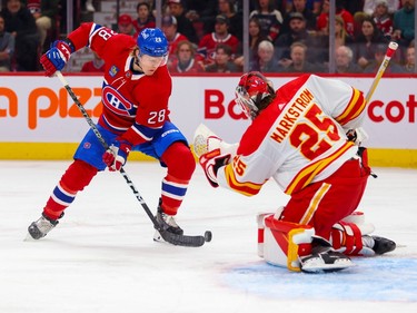 Canadiens' Christian Dvorak tries to control a rebound in front of Calgary Flames goaltender Jacob Markstrom during the first period of a National Hockey League game in Montreal Monday Dec. 12, 2022.