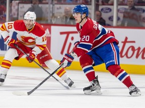 Canadiens' Juraj Slafkovsky looks to make a pass in front of Flames' Jonathan Huberdeau during third period Monday night at the Bell Centre.