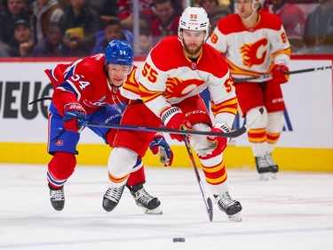 Canadiens Jordan Harris checks Calgary Flames Noah Hanifin during first period of National Hockey League game in Montreal Monday Dec. 12, 2022.