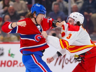 Canadiens' Michael Pezzetta throws a punch at Calgary Flames' Connor Mackey during a first period fight in a National Hockey League game in Montreal Monday Dec. 12, 2022.