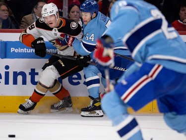 Anaheim Ducks defenceman Dmitry Kulikov (29) and Montreal Canadiens defenceman Jordan Harris (54) grimace as they try to keep each other away from the play during NHL action in Montreal, on Thursday, Dec. 15, 2022.