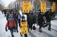 People walk on the street in the snow with banners calling for an end to road violence
