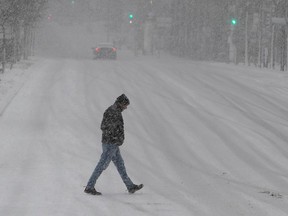 A lone pedestrian walks in downtown Montreal during a snowstorm in December 2022.