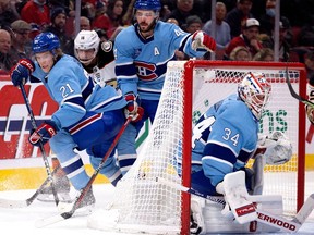 Montreal Canadiens defenceman Kaiden Guhle looks for the puck as goaltender Jake Allen covers the angle in Montreal on Dec. 15, 2022.