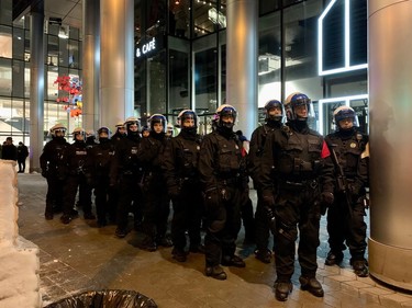 Riot police stand by as protesters march on the last day of COP15 in Montreal on Monday, Dec. 19, 2022.