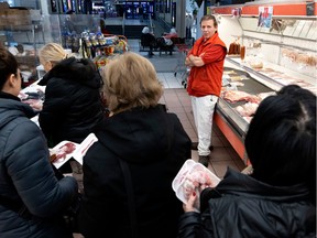 Sid Nemes, owner of J & R Kosher butcher, speaks with his clients as they wait to pay on Tuesday, Dec. 20, 2022.