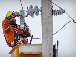 A Hydro-Québec repair technician works to restore power on 9th Ave. in the Lachine district of Montreal on December 24, 2022.