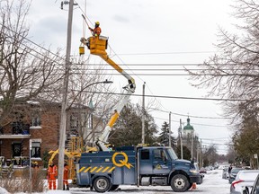 A Hydro-Québec repair technician works to restore power on 9th Ave. in the Lachine district of Montreal on Saturday, December 24, 2022.