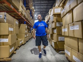 Boxing trainer Russ Amber walks through the warehouse of his rival boxing gear business in Montreal.