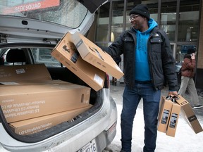 Abib Fall loads up his car with computer hardware during a Boxing Day event at the downtown Best Buy store Dec. 26, 2022.