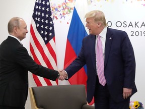 Russia's President Vladimir Putin shakes hands with then-U.S. President Donald Trump during a meeting in Osaka, Japan in 2019.