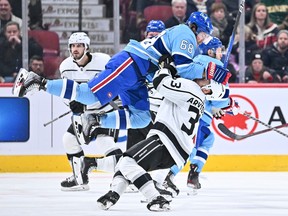 Canadiens' Mike Hoffman (68) jumps onto Viktor Arvidsson (33) of the Los Angeles Kings during the third period at the Bell Centre on Saturday, Dec. 10, 2022, in Montreal.