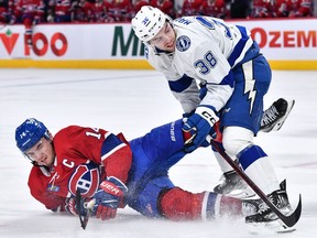 Tampa Bay Lightning's Brandon Hagel (38) takes down Canadiens' Nick Suzuki during the second period at the  Bell Centre on Saturday, Dec. 17, 2022, in Montreal.