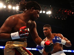 Anthony Joshua of Great Britain and Charles Martin of the United States wear rival boxing gloves during the IBF World Heavyweight Championship match at The O2 Arena in London, England, April 9, 2016.