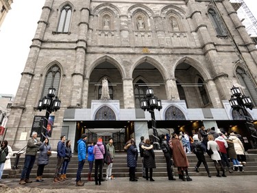 Tourists take advantage of an exceptionally warm late December day to line up to visit Notre-dame Basilica in Montreal, on Friday, Dec. 30, 2022.