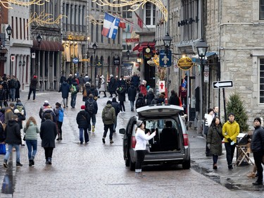 Tourists take advantage of an exceptionally warm late December day to line up to visit Old Montreal, on Friday, Dec. 30, 2022.