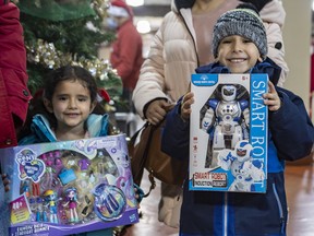 Welcome Hall Mission hosted its annual toy giveaway in Montreal on Saturday, Dec. 3, 2022, to the families it serves in its various programs. Five-year-old Luciana and seven-year-old Mariano Rincon hold onto their chosen Christmas gifts at the Mission’s toy giveaway.