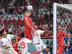 Team Canada defender Alistair Johnston heads the ball during a World Cup Group F match between Canada and Morocco at Al-Thumama Stadium in Doha on Dec. 1, 2022.