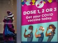 A pedestrian walks past a COVID-19 vaccination poster in Toronto in a photo taken in February.