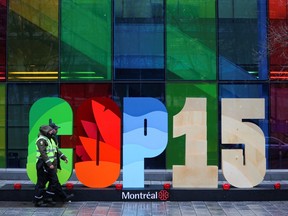Police officers walk past a sign as they patrol outside the Palais de Congres, during the opening of COP15, the two-week UN biodiversity summit in Montreal, December 6, 2022.