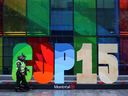 Police officers walk past a sign as they patrol outside the Palais de Congres, during the opening of COP15, the two-week UN biodiversity summit in Montreal, December 6, 2022.